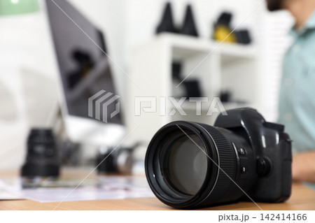 Photographer's workplace with professional camera in office Photographer's workplace with professional camera in office 142414166