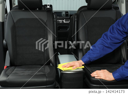 Car wash worker cleaning automobile interior, closeup Car wash worker cleaning automobile interior, closeup 142414173