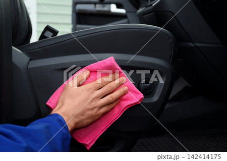 Car wash worker cleaning automobile interior, closeup Car wash worker cleaning automobile interior, closeup 142414175