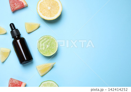 Flat lay composition with citrus essential oil on light blue background. Space for text 142414252