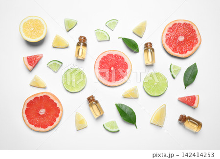 Flat lay composition with bottles of citrus essential oil on white background Flat lay composition with bottles of citrus essential oil on white background 142414253