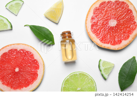 Flat lay composition with bottle of citrus essential oil on white background Flat lay composition with bottle of citrus essential oil on white background 142414254