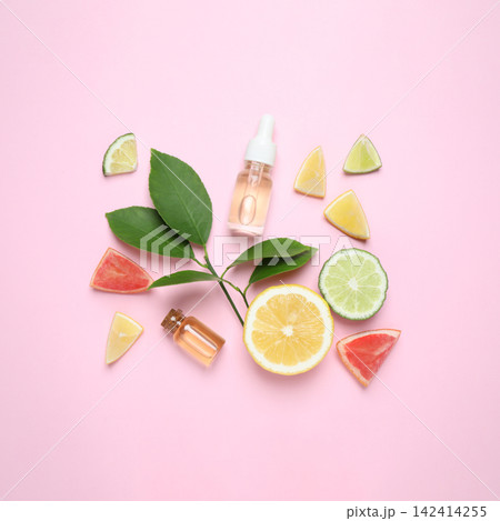 Flat lay composition with bottles of citrus essential oil on pink background Flat lay composition with bottles of citrus essential oil on pink background 142414255
