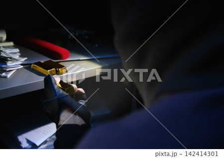 Thief taking gold bars out of steel safe indoors at night, closeup Thief taking gold bars out of steel safe indoors at night, closeup 142414301