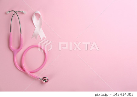 Pink ribbon as breast cancer awareness symbol and stethoscope on color background, flat lay. Space for text Pink ribbon as breast cancer awareness symbol and stethoscope on color background, flat lay. Space for text 142414303