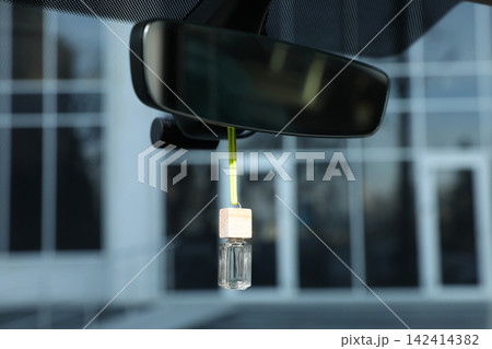 Air freshener hanging on rear view mirror in car Air freshener hanging on rear view mirror in car 142414382
