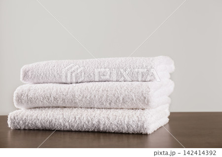 Stack of clean bath towels on dark grey table Stack of clean bath towels on dark grey table 142414392