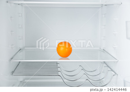 Fresh juicy orange on empty shelf in refrigerator 142414446