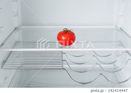 Fresh ripe tomato on empty shelf in refrigerator 142414447