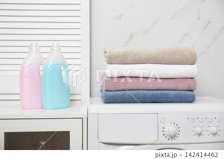 Stack of fresh towels and detergents in laundry room 142414462