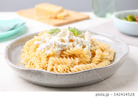 Tasty pasta with sauce and basil on white wooden table, closeup Tasty pasta with sauce and basil on white wooden table, closeup 142414528