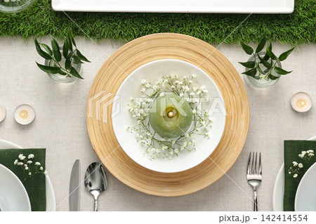 Elegant table setting with green plants on light cloth, flat lay Elegant table setting with green plants on light cloth, flat lay 142414554