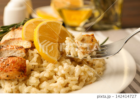 Delicious chicken risotto with lemon on table, closeup Delicious chicken risotto with lemon on table, closeup 142414727