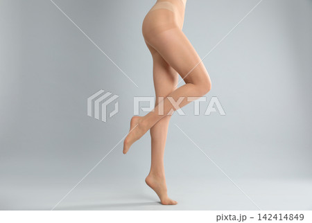 Woman wearing tights on light grey background, closeup of legs Woman wearing tights on light grey background, closeup of legs 142414849