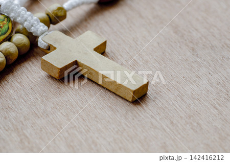 Side view of Holy Rosary on wooden table with customizable space for text. Religion concept. 142416212
