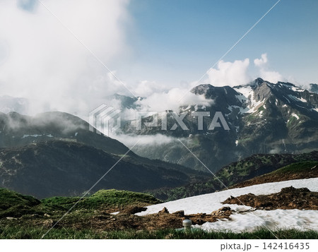 Dramatic alpine panorama from the Mindelheim Via Ferrata in the Allgaeu Alps, Germany, partially snow covered mountain slopes and rugged peaks emerging through clouds, cinematic adventure travel Dramatic alpine panorama from the Mindelheim Via Ferrata in the Allgaeu Alps, Germany, partially snow covered mountain slopes and rugged peaks emerging through clouds, cinematic adventure travel 142416435