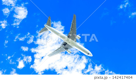 爽やかな青空の下爆音をあげて着陸態勢に入ったかっこいい飛行機 142417404