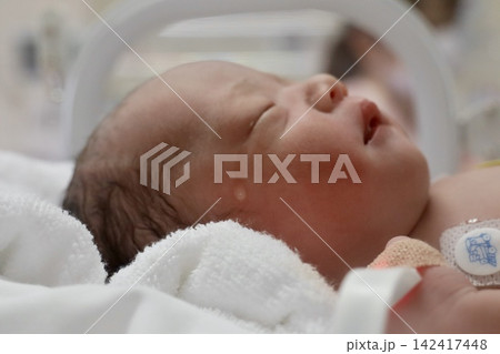 出産直後の新生児、保育器で眠る涙の横顔|出産・育児・生命を伝えるWeb・広告素材 出産直後の新生児、保育器で眠る涙の横顔|出産・育児・生命を伝えるWeb・広告素材 142417448