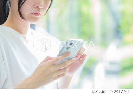 スマートフォンを使う看護師の女性 スマートフォンを使う看護師の女性 142417760