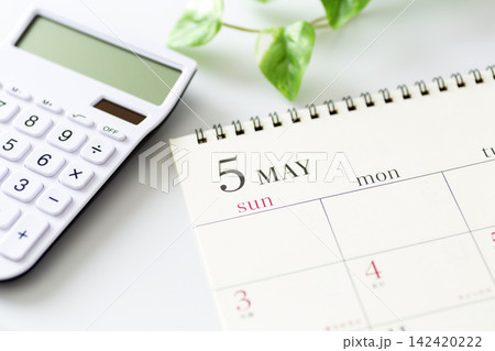 5月のカレンダーと白い電卓 5月のカレンダーと白い電卓 142420222