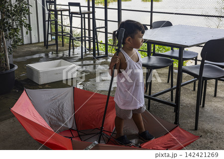 Asian Toddler Playing With Red Umbrella 142421269
