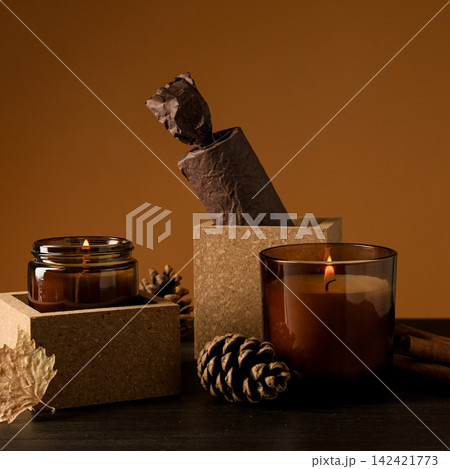 Candles, cinnamon and cones on brown background Candles, cinnamon and cones on brown background 142421773