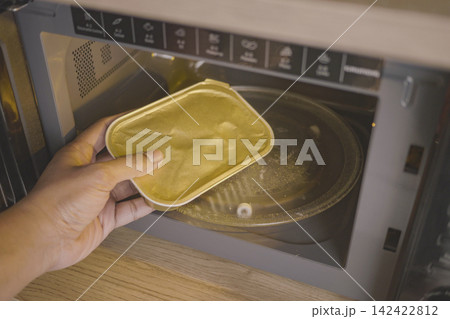 Heating food in a microwave oven at home Heating food in a microwave oven at home 142422812