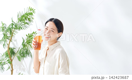 ペットボトルのお茶を飲む女性。水分補給、ウーロン茶、緑茶、紅茶、麦茶、水分補給、飲み物、ジュース ペットボトルのお茶を飲む女性。水分補給、ウーロン茶、緑茶、紅茶、麦茶、水分補給、飲み物、ジュース 142423687