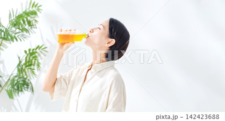 ペットボトルのお茶を飲む女性。水分補給、ウーロン茶、緑茶、紅茶、麦茶、水分補給、飲み物、ジュース ペットボトルのお茶を飲む女性。水分補給、ウーロン茶、緑茶、紅茶、麦茶、水分補給、飲み物、ジュース 142423688