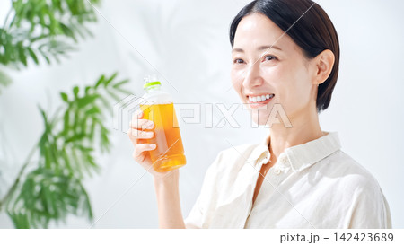 ペットボトルのお茶を飲む女性。水分補給、ウーロン茶、緑茶、紅茶、麦茶、水分補給、飲み物、ジュース 142423689