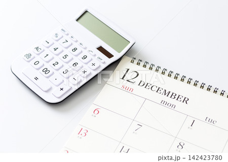 12月のカレンダーと白い電卓 12月のカレンダーと白い電卓 142423780