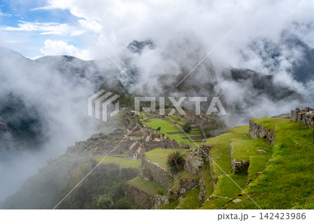 Panoramic view of Machu Picchu ruins surrounded by misty mountains, Peru Panoramic view of Machu Picchu ruins surrounded by misty mountains, Peru 142423986