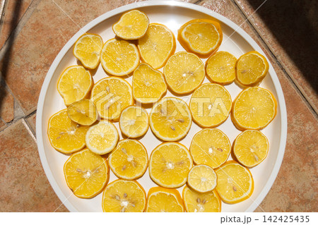 Fresh Lemon Slices Drying in the Sun on a White Plate 142425435