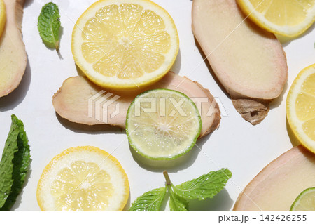 Healthy ingredients featuring yellow lemon, green lime, fresh ginger, and mint 142426255