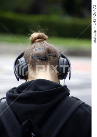 Woman in the steet with headphones Woman in the steet with headphones 142426472