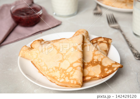Folded fresh thin pancakes on light grey table Folded fresh thin pancakes on light grey table 142429120