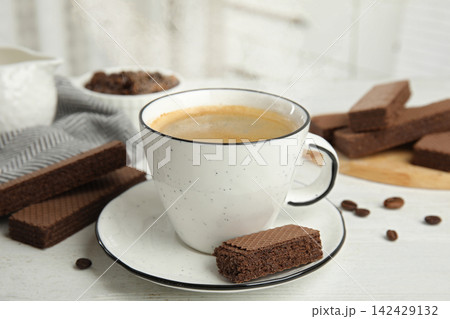 Delicious wafers and cup of coffee for breakfast on white wooden table Delicious wafers and cup of coffee for breakfast on white wooden table 142429132