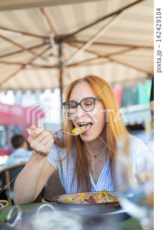 Woman enjoying lunch outdoors at a restaurant 142429184