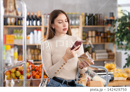 Young woman scanning qr code of cheese Young woman scanning qr code of cheese 142429750