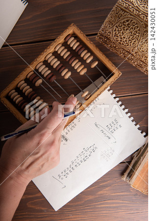Vintage tone of Man's hands accounting with old abacus and hold electronic calculator. picture financial concept design. Vintage tone of Man's hands accounting with old abacus and hold electronic calculator. picture financial concept design. 142430051