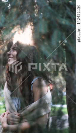 Portrait of a very beautiful young woman in a summer spruce forest at sunset. Portrait of a very beautiful young woman in a summer spruce forest at sunset. 142431156