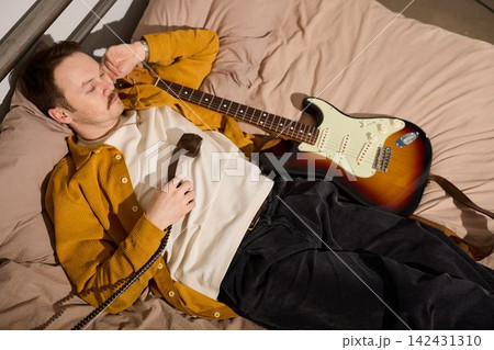 Man with acoustic guitar pens song ideas in calm solitude Man with acoustic guitar pens song ideas in calm solitude 142431310