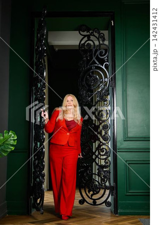 Woman in red. Woman in crimson attire readies for appearance Woman in red. Woman in crimson attire readies for appearance 142431412