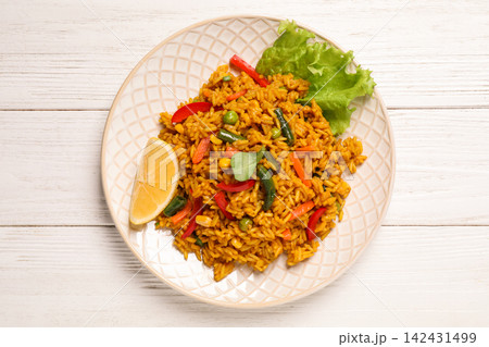 Delicious rice pilaf with vegetables on white wooden table, top view Delicious rice pilaf with vegetables on white wooden table, top view 142431499