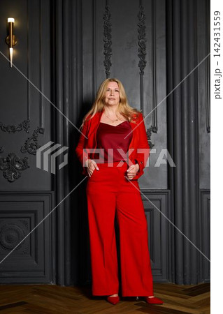 Elegant businesswoman in red suit with commanding presence Elegant businesswoman in red suit with commanding presence 142431559