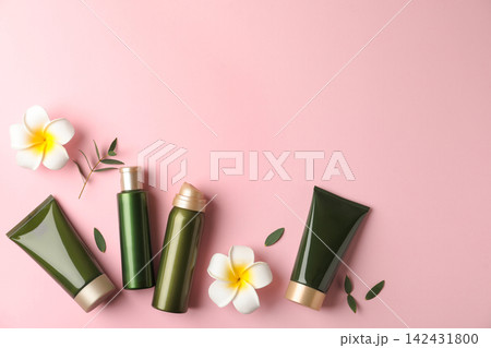 Flat lay composition with cosmetic products and tropical flowers on pink background. Space for text 142431800