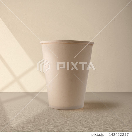 Minimalist blank beige paper cup mockup on textured surface with soft window shadows. Mockup or Copyspace Minimalist blank beige paper cup mockup on textured surface with soft window shadows. Mockup or Copyspace 142432237