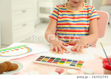 Cute little child painting with palms at pink table, closeup 142432743
