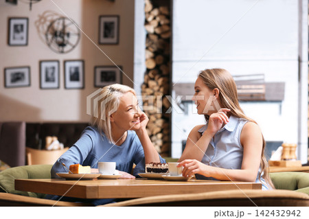 Mother and her adult daughter spending time together in cafe 142432942