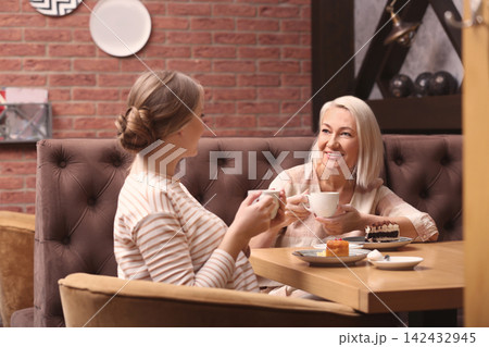 Mother and her adult daughter spending time together in cafe Mother and her adult daughter spending time together in cafe 142432945